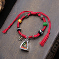 Antique Tibetan silver Gau box pendant with Medicine Buddha image inside, strung on a hand-braided red cord bracelet