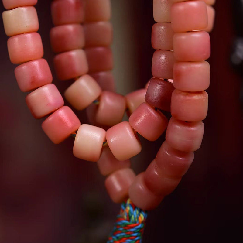 Close up of natural camel bone mala beads with reddish half-blood pattern and earthy texture