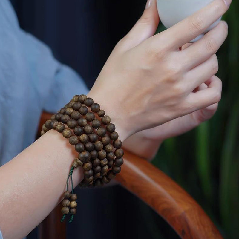 Agarwood Mala 108 Beads worn on wrist, showcasing premium oud wood prayer beads for meditation.