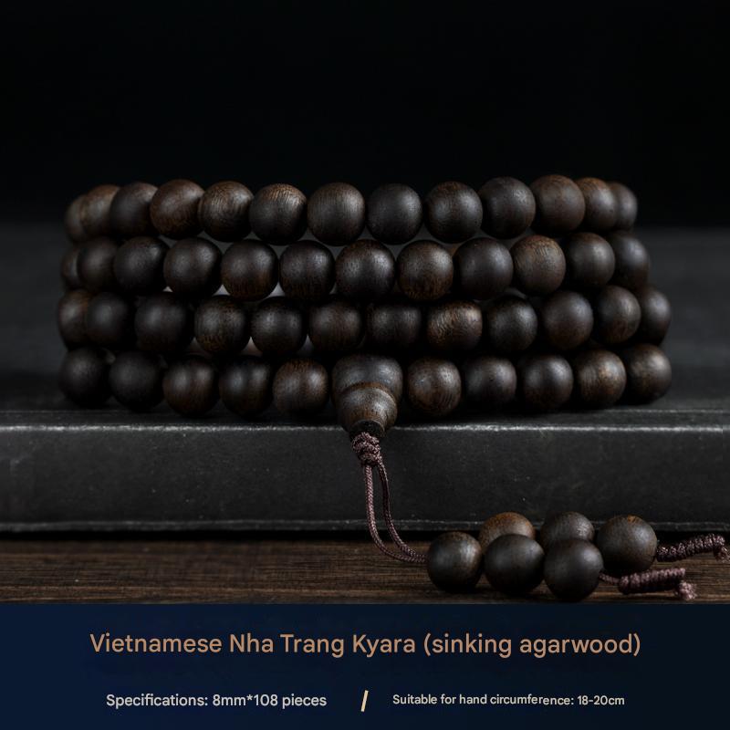 Agarwood mala resting on meditation altar with incense and singing bowl