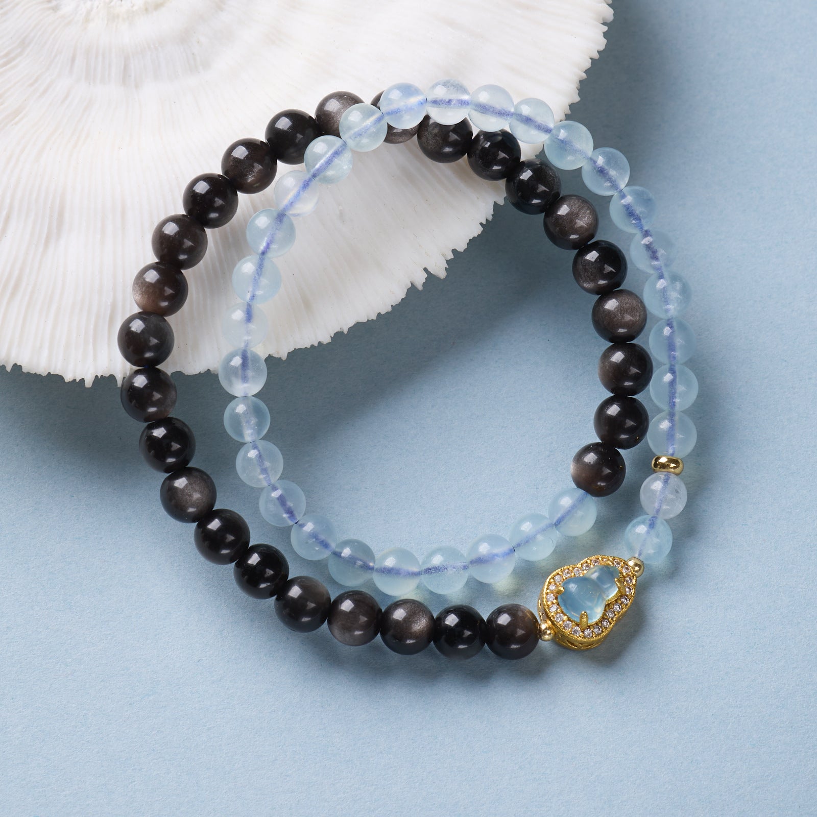 Black obsidian bracelet resting on meditation altar with singing bowl