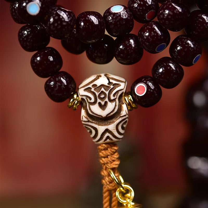 Close-up of Natural Cinnabar Star Seed Bodhi Mala showing intricate bead designs and unique pendant.