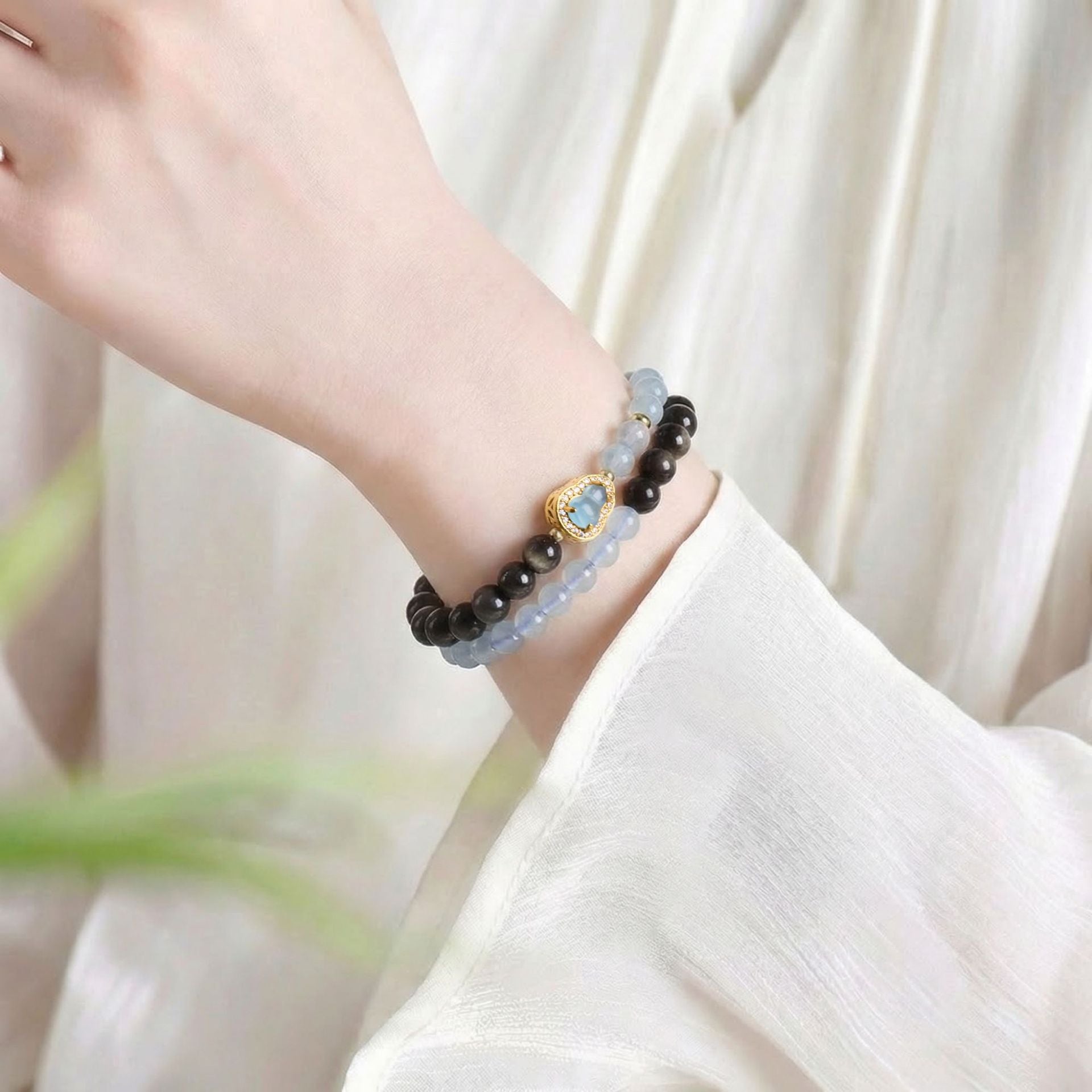 Double wrap bracelet worn on wrist, black obsidian and aquamarine healing beads