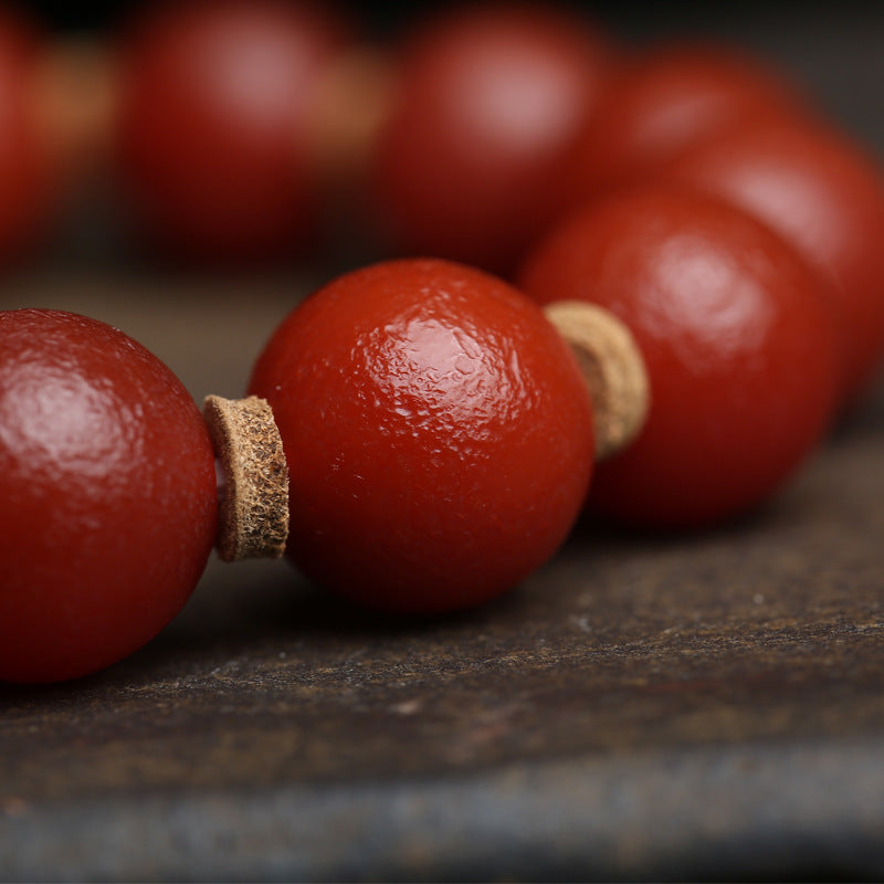 Close up of natural red agate beads on single wrap bracelet showing authentic color variations