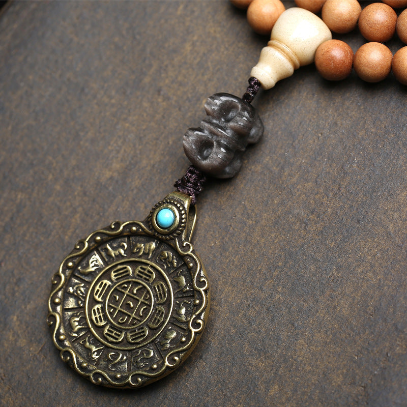 Close up of Tibetan Nine Palace Diagram Mewa Gu pendant showing Bagua and zodiac animals