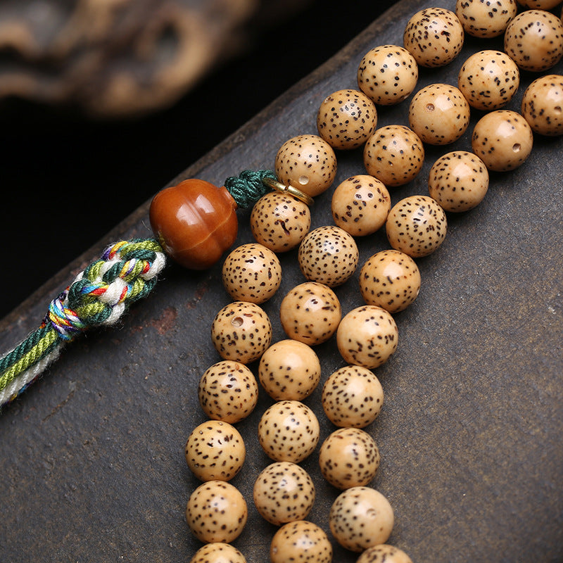 Close-up of hand-carved lotus wooden pendant on star moon bodhi mala beads