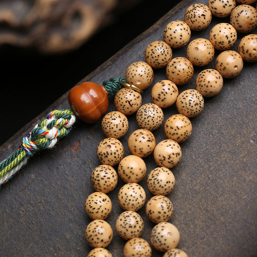 Close-up of hand-carved lotus wooden pendant on star moon bodhi mala beads