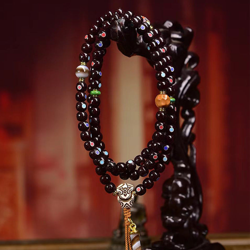 Natural Cinnabar Star Seed Bodhi Mala displayed on ornate stand, showcasing its beautiful 108 beads for meditation.