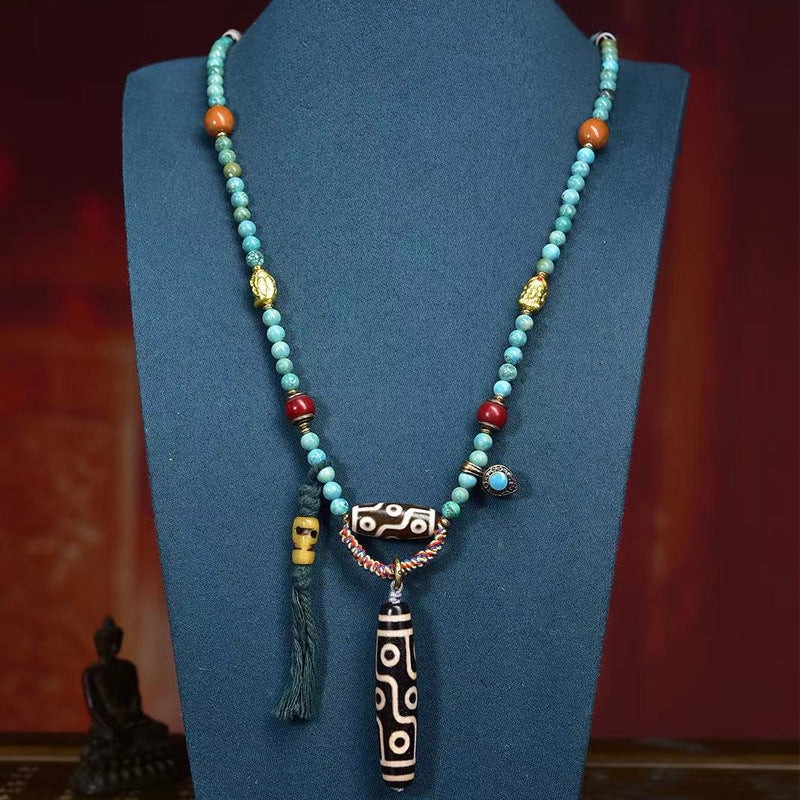 Turquoise Tibetan mala worn as multi-loop bracelet with dzi bead pendant
